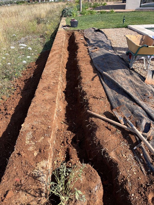 An irrigation trench opened for first fix before hard surfaces are laid