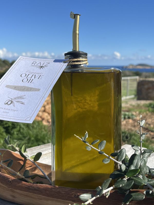Una botella de aceite de oliva con el mar al fondo