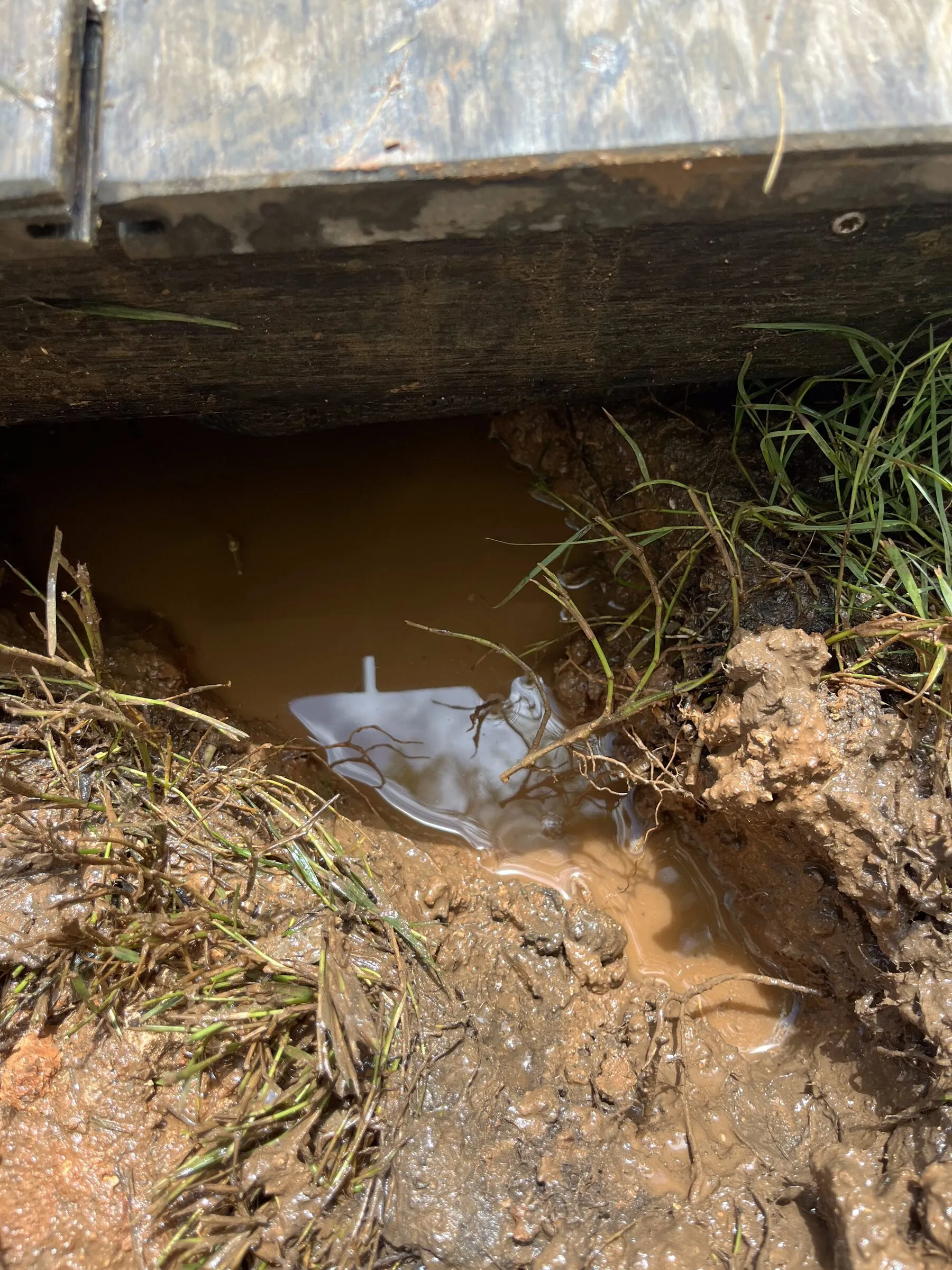 A new coupling repair sitting in a trench still full of water